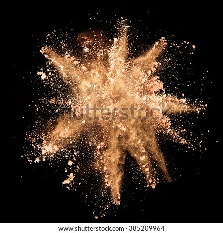Explosion of brown powder on black background