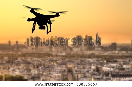 Drone silhouette flying above Paris city panorama