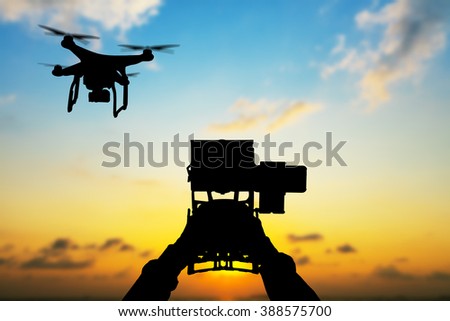 Man hands handling drone in sunset silhouettes