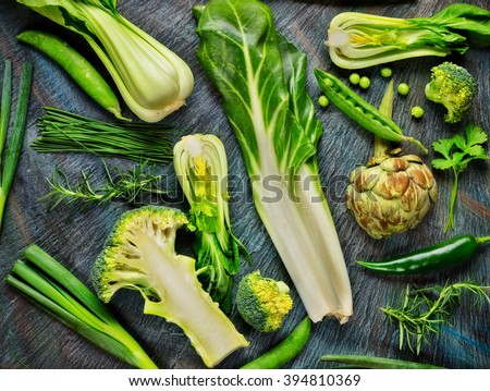 Collection of fresh green vegetables placed on black stone