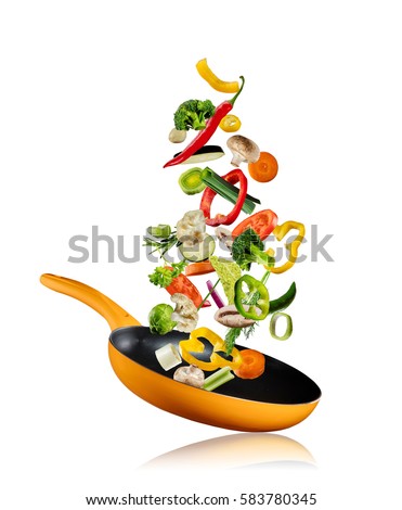 Fresh vegetables flying into a pan, isolated on white background