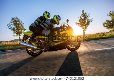 Motorbikers on sports motorbike riding in sunset. Outdoor photography, European landscape. Travel and sport photography. Motorbike is manufactured and designed in Japan