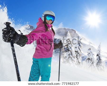 Happy young woman skier enjoying sunny weather in Alps. Winter sport and recreation, leasure outdoor activities.