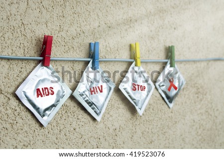 condom and sealed condoms on colorful clothespins. aids  ribbon symbolic concept. help campaign on people  support on HIV STD heart disease. World Remembrance Day of AIDS Victims. sun filter