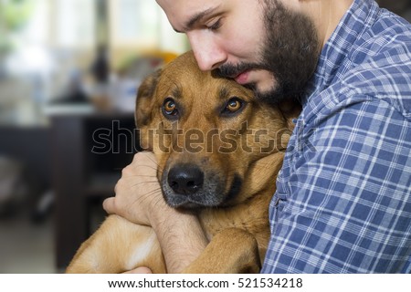Portrait of a handsome man hugging his lovely golden red dog.