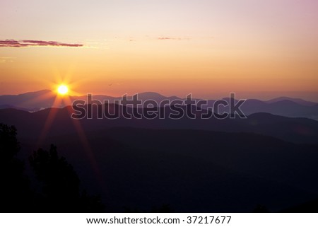 Sun just peaks over the mountain ridge.jpg