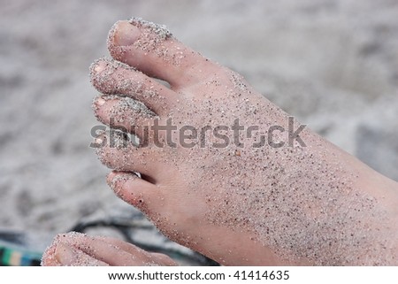 Woman\'s sandy foot at the beach