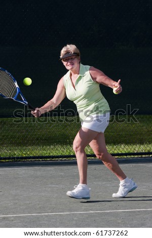 Senior woman tennis player about to hit a forehand shot