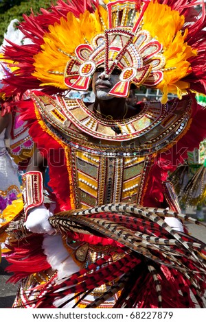 NASSAU, THE BAHAMAS - JANUARY 1 - Male dancer dressed in orange and red feathers, dances in Junkanoo, a traditional island cultural festival on Jan 1, 2011 in Nassau