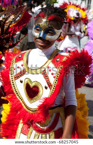 NASSAU, THE BAHAMAS - JANUARY 1 - Female dancer dressed in bright orange feathers and red hearts, dances in Junkanoo, a traditional island cultural festival in Nassau, Jan 1, 2011