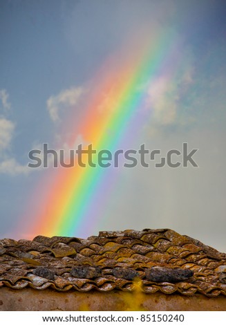 Rainbow over tiled roof in Sicily