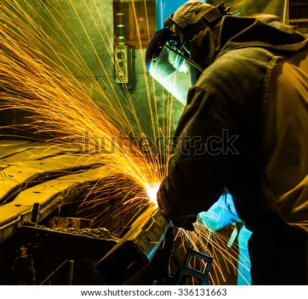 worker in automotive industry,welding working repair and grinding parts.