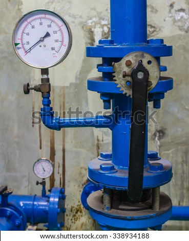 Water pressure gauge meter installed on a blue pipe