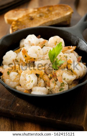 Closeup of shrimp in a garlic, butter and herb sauce.