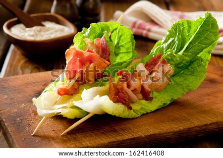 Bacon and romaine salad skewers with blue cheese dressing.