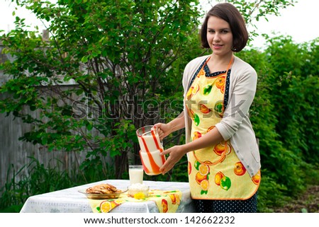 happy woman with fresh diary and cakes in garden