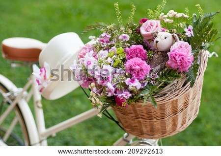 white retro bike with flowers and toys in a basket