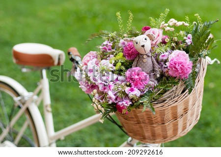 white retro bike with flowers and toys in a basket
