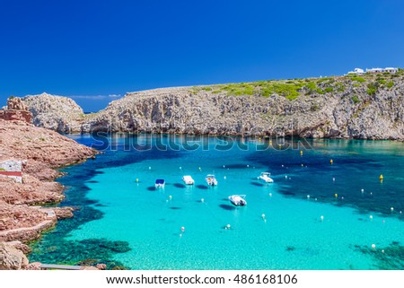 Cala Morell cove with its red rocks and crystal clear blue water, Menorca island, Balearic Islands, Spain.