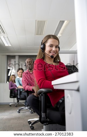 Businesswoman and co-workers working in cubicles