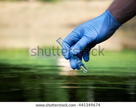 Water sample. Hand in glove collects water in a test tube. Concept - water purity analysis, environment, ecology. Water testing for infections, permission to swim