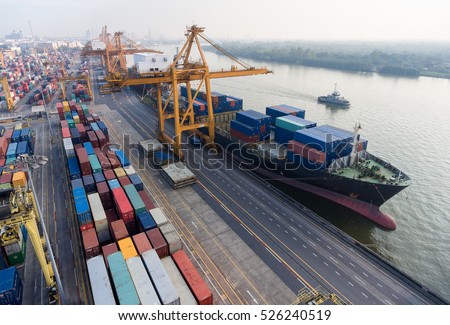 container ship in import export and business logistic.By crane , Trade Port , Shipping.Tugboat assisting cargo to harbor.Aerial view.In Thailand.