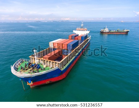 container,container ship in import export and business logistic.By crane , Trade Port , Shipping.Tugboat assisting cargo to harbor.Aerial view.Water transport.International.Shell Marine.