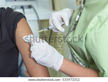 Close-up hands,nurses are vaccinations to patients using the syringe.Doctor vaccinating women in hospital.Are treated by the use of sterile injectable upper arm.