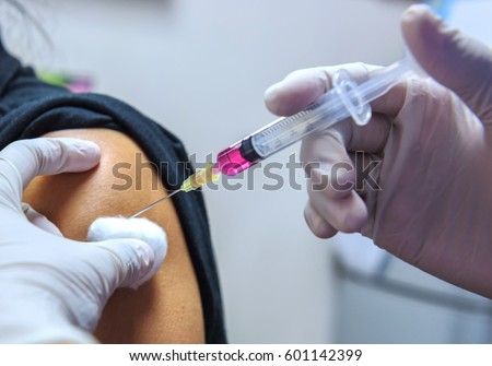 Close-up hands,nurses are vaccinations to patients using the syringe.Doctor vaccinating women in hospital.Are treated by the use of sterile injectable upper arm. injection