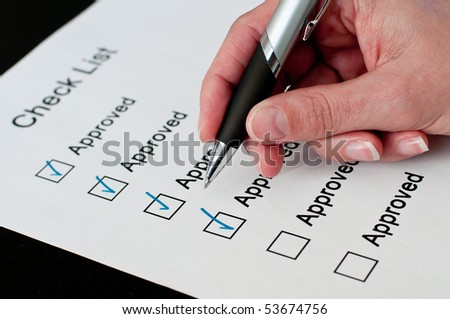 Female hand approving on checklist