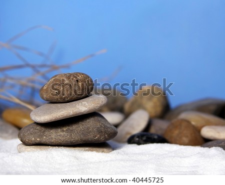 Stones piled on white sand with blue sky