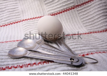 high-key image of whole egg in measuring spoon