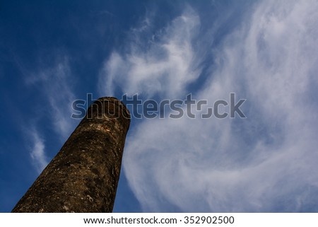 Soft focus of the pillars of the temple in Sukhothai Historical Park, with a cloudy sky like smoke as background.