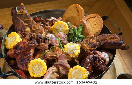 Various kind of grilled meat arranged on wooden plate