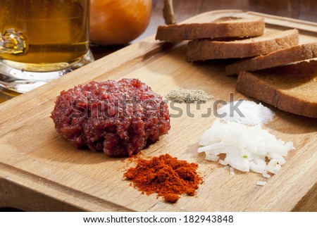 Steak tartar ready to eat on the wooden trencher