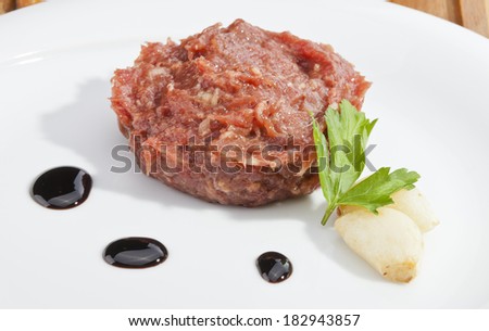Steak tartar ready to eat on the wooden trencher