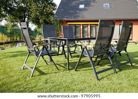 The metal Garden furniture by the house and the pool
