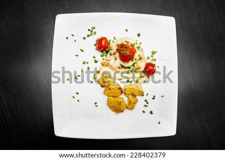 Fried chicken  with tomato and potato served on the white plate