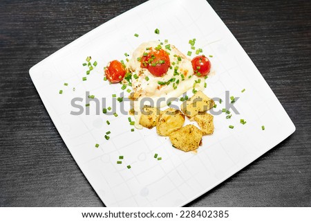 Fried chicken  with tomato and potato served on the white plate