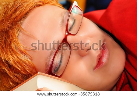woman with eye glasses lying on books, sleeping