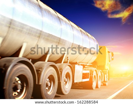 yellow truck on blurry asphalt road under blue sky and sunset light