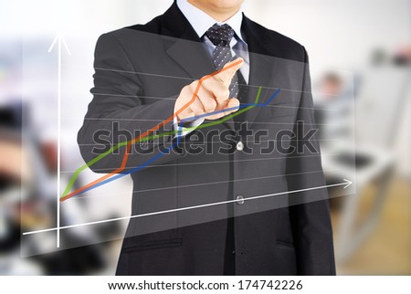 the Image of male hand pointing at business graphics