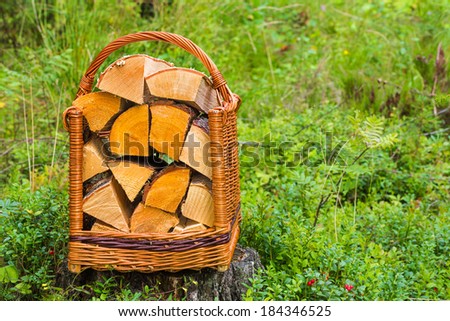 basket with firewood costs on a stone among the wood