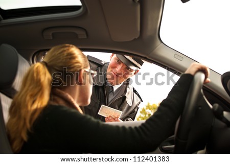 Police officer is doing a traffic check and is looking at a drivers license