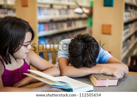 Teenagers in a library a tired of learning and felt to sleep
