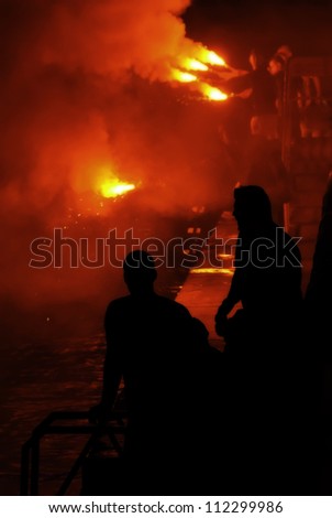 Revelers during the feast at St Julian in Malta engulfed in smoke tinged red from the flares they were lighting over water.