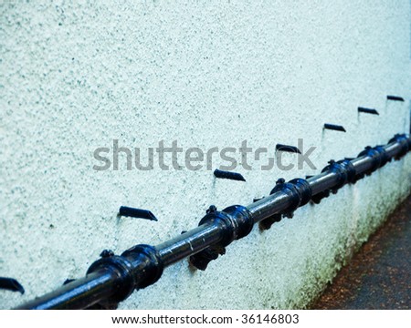 A whitewashed wall with drain pipes sticking out