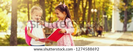 Child going to school. girl holding books and pencils. Little students excited to be back to school. Beginning of class after vacation.