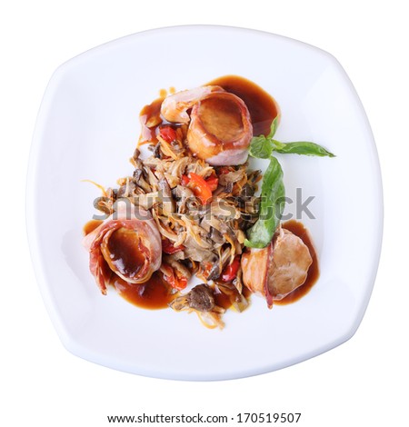 Medallions of pork wrapped in bacon with oyster mushrooms and sauce  on a white dish isolated over white background. Top view.
