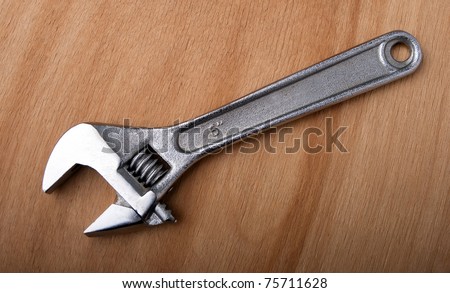 Adjustable spanner isolated on wooden board